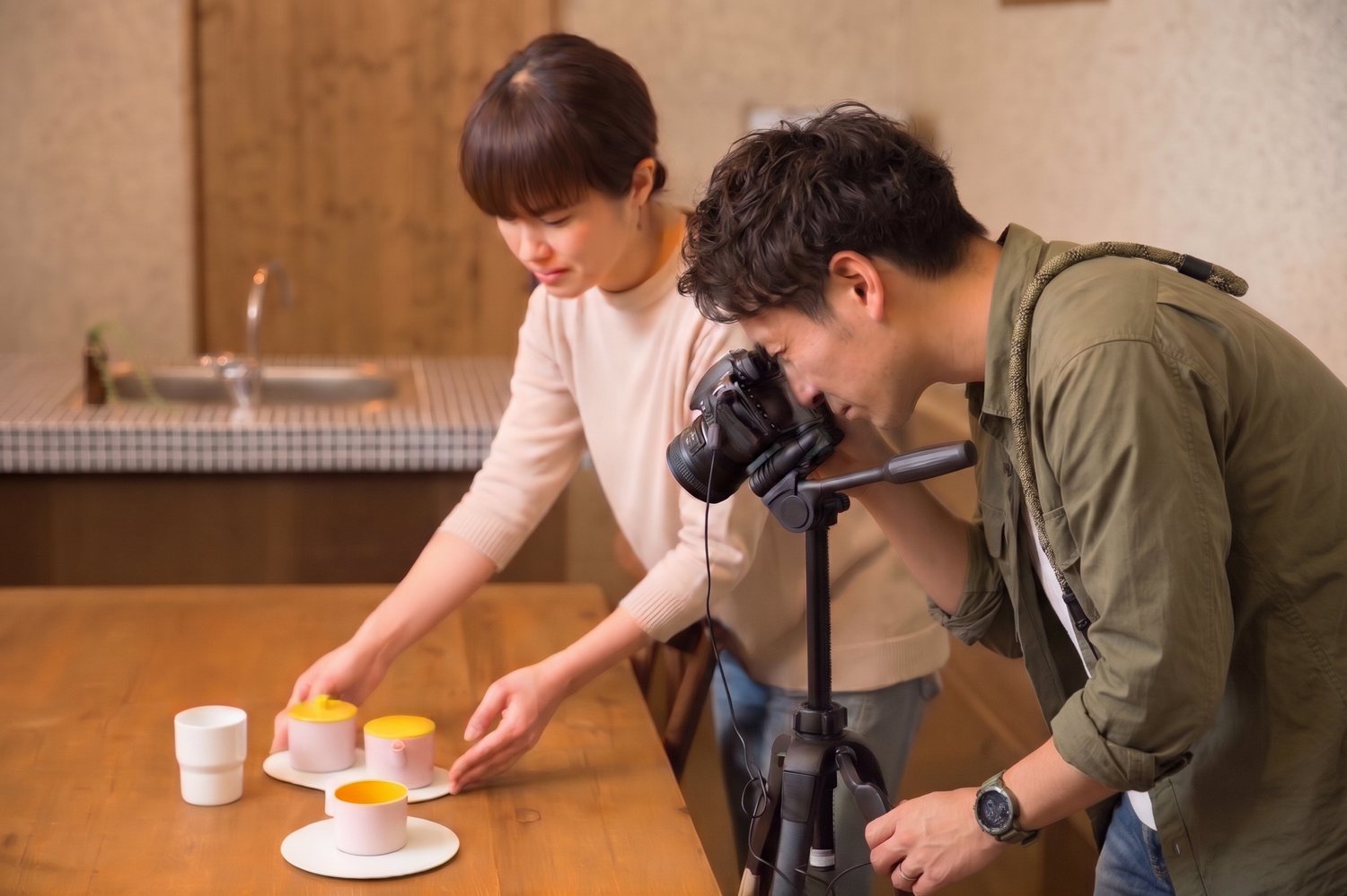 器を並べて商品撮影をするスタッフ