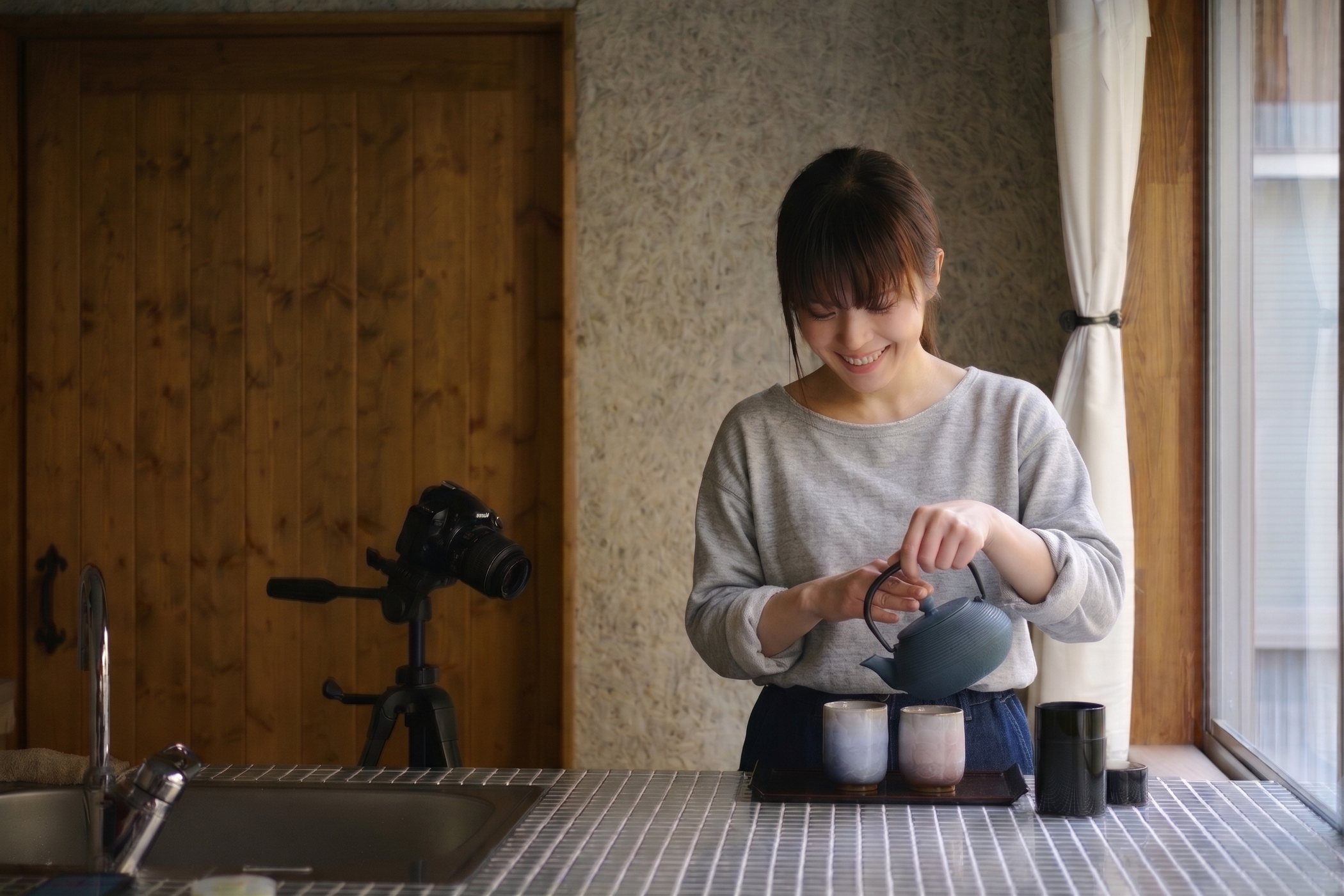 撮影スタジオで鉄瓶のお茶を注ぐスタッフ